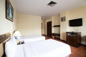 um quarto de hotel com duas camas e uma televisão de ecrã plano em Night Bazaar Place em Chiang Mai