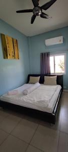 a bed in a bedroom with a ceiling fan at บ้านพักในสวนK&N2 