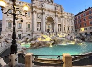 una fontana di fronte a un edificio di Adelaide Suite Dreams a Roma