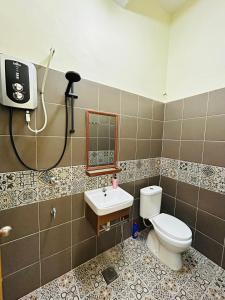 a bathroom with a toilet and a sink at Sena Yang Indah Homestay in Kangar