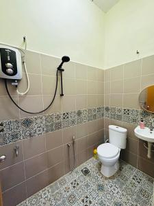 a bathroom with a toilet and a shower and a sink at Sena Yang Indah Homestay in Kangar
