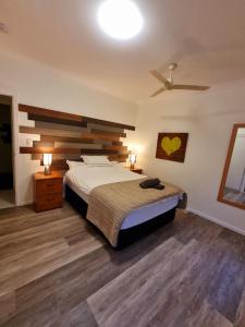 a bedroom with a bed and a ceiling fan at Seaside holiday house in Burrum Heads