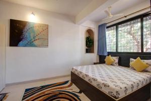 a bedroom with a bed and a large window at Rahul Service Apartment in Calangute