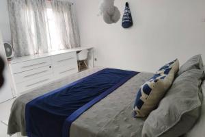 1 dormitorio con cama con sábanas azules y ventana en Nichi's Guesthouse - Cosy 3 bedroom with breakfast en Blantyre