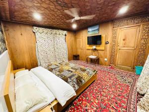 1 dormitorio con 1 cama, TV y alfombra en The Hayat Group Of Houseboats, en Srinagar