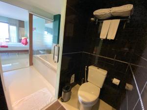 y baño con aseo y ducha. en Siam Triangle Hotel, en Chiang Saen