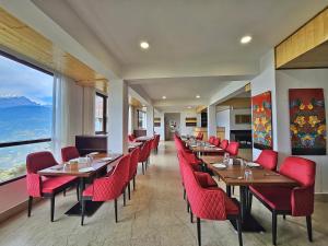 un restaurante con mesas de madera y sillas rojas en Sumitel Pelling en Pelling