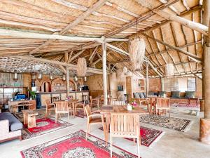 a dining room with tables and chairs in a building at Café Gili Beach Bungalows in Gili Meno