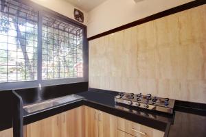 a kitchen with a sink and a stove and a window at Rahul Service Apartment in Calangute