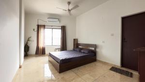 een slaapkamer met een bed en een raam bij Downtown Manor-Panavila in Trivandrum