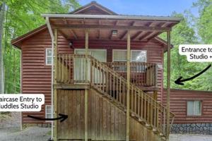 a small wooden cabin with a large deck at Cuddles, 1 Bedroom Studio, Walk to Downtown and Hiking Trails! in Gatlinburg