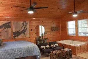 a bedroom with a bed and a tub in a room at Cuddles, 1 Bedroom Studio, Walk to Downtown and Hiking Trails! in Gatlinburg