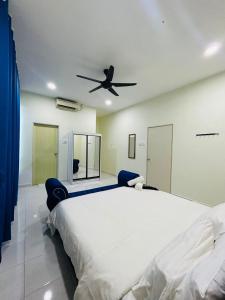a bedroom with a large bed with a ceiling fan at Paddy View Homestay in Kangar