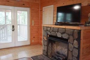 a living room with a fireplace with a tv on top of it at Cuddles, 1 Bedroom Studio, Walk to Downtown and Hiking Trails! in Gatlinburg