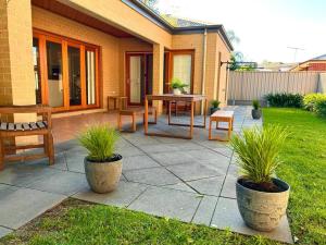 a patio with a table and chairs in a yard at Grand retreat in peaceful street in Wodonga