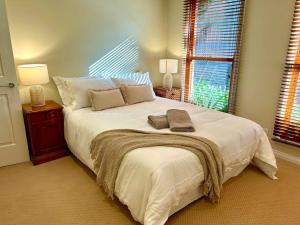 a bedroom with a large white bed with two lamps at Grand retreat in peaceful street in Wodonga