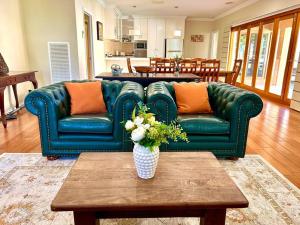 a living room with a green couch and a table at Grand retreat in peaceful street in Wodonga