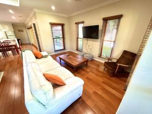a living room with a white couch and a table at Grand retreat in peaceful street in Wodonga