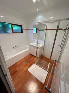 a bathroom with a shower and a tub and a sink at Grand retreat in peaceful street in Wodonga