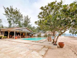 un complejo con piscina frente a un edificio en BUNGALOW CAFE GILI BEACH FRONT en Gili Meno