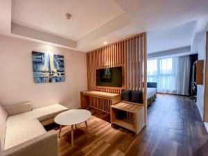 una pequeña sala de estar con sofá y TV en Holiday Inn Express Zhangjiakou Park View, an IHG Hotel en Zhangjiakou