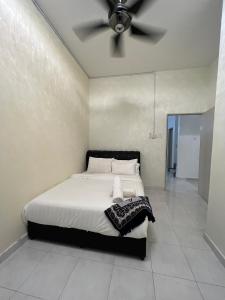 a bedroom with a bed with a ceiling fan at Paddy View Homestay in Kangar