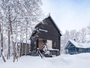 ニセコ町にあるShousugi Chalet by Elite Havensの屋根に雪が積もった木造家屋