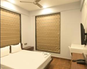 a bedroom with a white bed and a window at NK7 Newtown in kolkata