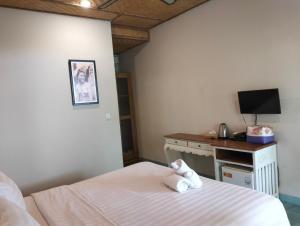 a bedroom with a bed with a stuffed animal on it at Jukung Dua Guest House in Sanur