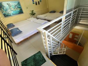 a room with two beds and a staircase at Tony's Homestay in Ấp Thiện Phước