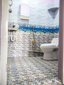 a bathroom with a toilet and a mosaic floor at NAKSHATHRA Guest House 2BHK in Tiruvannāmalai