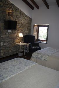 a bedroom with two beds and a stone wall at Puial de l Douro in Miranda do Douro +52 photos