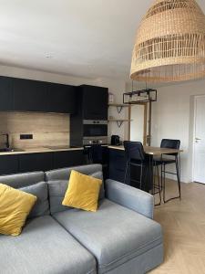 a living room with a couch and a kitchen at Appartement moderne avec garage et accès métro à 100m in Villeurbanne
