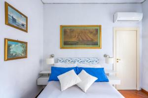 een slaapkamer met een bed met blauwe en witte kussens bij La Casa Di Bruno Napoli in Napels