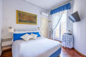 Dormitorio azul y blanco con cama y ventana en La Casa Di Bruno Napoli, en Nápoles