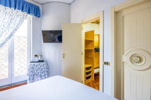 una camera con letto bianco e armadio di La Casa Di Bruno Napoli a Napoli