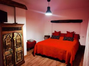 a bedroom with a red bed and a wooden floor at Spiaggia da Monic in Trevignano Romano