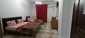 een slaapkamer met een bed en een rood gordijn bij Aramca in Bab Ezzouar