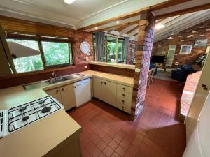 una cocina con fregadero y estufa horno superior en Creek cottage, en Wodonga