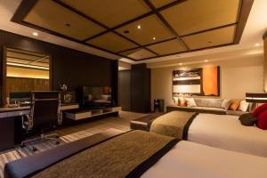 una camera d'albergo con due letti e un divano di Hofu Grand Hotel a Hofu