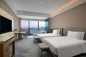 a hotel room with two beds and a flat screen tv at Crowne Plaza Chaozhou Riverside, an IHG Hotel in Chaozhou