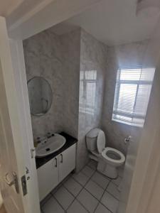 a bathroom with a toilet and a sink and a mirror at 31 Riverview in Cape Town