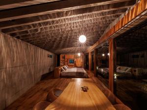 奄美市にあるDenpaku The Beachfront MIJORAのベッドと木製テーブルが備わる客室です。
