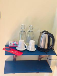 a blue shelf with two glass bottles and a tea kettle at Zen Boutique House in Luang Prabang
