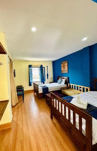 a bedroom with two beds and a blue wall at Zen Boutique House in Luang Prabang