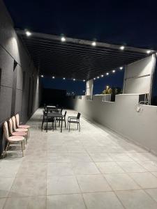 النظافه والجوده في الرياض: مجموعة من الطاولات والكراسي على الفناء في الليل