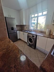 una cocina con lavadora y secadora. en 31 Riverview en Ciudad del Cabo