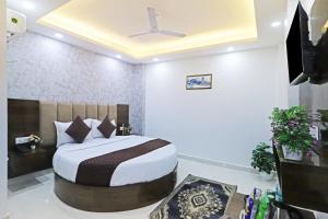 a bedroom with a bed and a ceiling fan at Hotel Vijaydeep Palace Near Delhi Airport in New Delhi