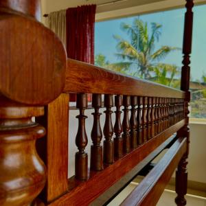 a wooden stair railing with a view of a palm tree at Santa Maria, Trivandrum - An Airport Boutique by the Sea in Trivandrum