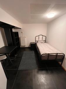 een kleine slaapkamer met een bed en een bureau bij Au cœur de Bruxelles in Brussel